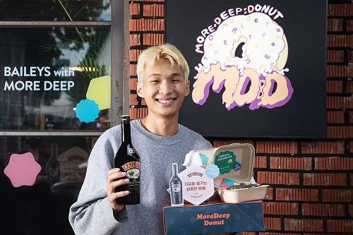 ▲도넛 브랜드 ‘모어딥도넛’ 유성근 대표가 세계 판매 1위 리큐어 브랜드 베일리스와 협업해 선보인 신메뉴와 함께 기념촬영을 하고 있다. / 사진=디아지오코리아