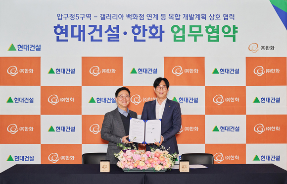 ▲지난 26일 신사동에 위치한 디에이치 갤러리에서 이인기 현대건설 본부장(왼쪽), 윤성호 ㈜한화 본부장이 업무협약을 체결한 후 기념사진을 촬영하고 있다. / 사진=현대건설 현대건설·㈜한화, 압구정5구역 복합개발 나선다