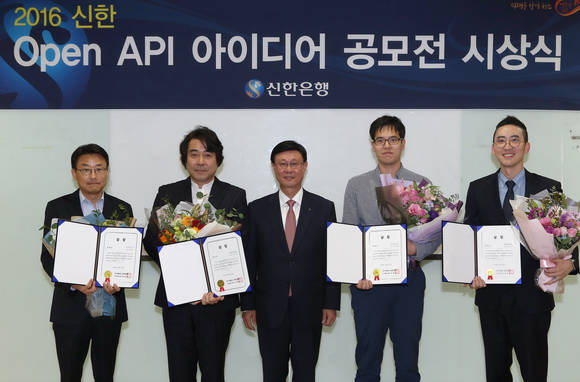 ▲서울 중구 소재 신한은행 본점에서 진행된 ‘2016 신한 Open API 아이디어 공모전’ 시상식에서 신한은행 유동욱 부행장(왼쪽에서 세번째)과 수상자들이 기념촬영하는 모습.(사진제공=신한은행)