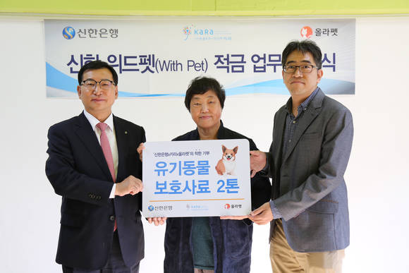▲지난 18일 서울 마포구 서교동 소재 카라 더불어숨센터에서 진행된 ‘신한 위드펫(With Pet)적금 업무협약식’에서 신한은행 고윤주 부행장(왼쪽), 동물보호단체 카라(KARA) 임순례 대표이사(가운데), 반려동물 커뮤니티 올라펫 정진만 대표이사(오른쪽)가 기념촬영 하는 모습.(사진제공=신한은행)