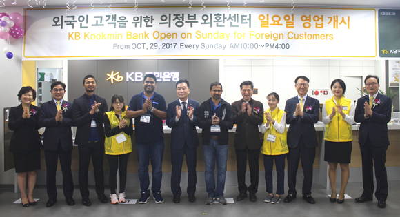 ▲KB국민은행이 경기 북부권 지역 외국인근로자의 금융편의 제공을 위해 의정부시에 '의정부 외환센터'를 개설하고 개점식을 가졌다. 사진 왼쪽부터 최미경 KB국민은행 외국고객부장(첫 번째), 신선균 KB국민은행 경기북지역영업그룹대표(두 번째), 김상수 KB국민은행 의정부중앙종합금융센터장(여섯 번째), 김남일 KB국민은행 중소기업금융그룹대표 (열 번째), 이환주 KB국민은행 외환사업본부장(열두 번째).(사진출처=KB국민은행)