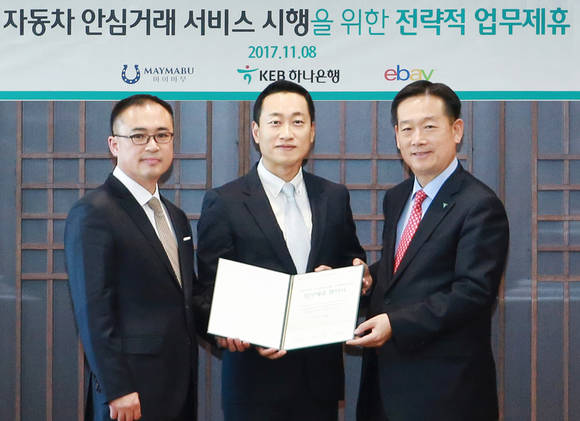 ▲KEB하나은행은 이베이코리아 및 마이마부와 '자동차 안심거래 서비스'의 시행을 위한 3사간 전략적 업무제휴를 체결했다고 밝혔다. 사진은 업무제휴 체결 후 오태균 KEB하나은행 영업지원그룹 전무(사진 오른쪽), 전항일 이베이코리아 통합영업본부 부사장(사진 가운데), 양인수 ㈜마이마부 대표(사진 왼쪽)가 기념사진 촬영을 하고 있는 모습.(사진제공=KEB하나은행)