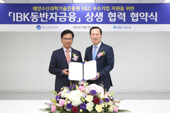 ▲김도진 기업은행장(오른쪽)과 연영진 해양수산과학기술진흥원 원장이 협약식을 마치고 기념촬영을 하고 있다.(사진제공=기업은행)