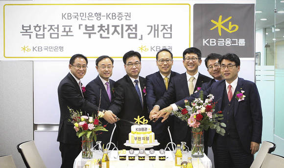 ▲지난 11일 개최된 KB국민은행-KB증권 복합점포 개점행사에서 양재영 KB국민은행 부천지역영업그룹 대표(왼쪽 첫번째), 이재형 KB증권 WM총괄본부장(오른쪽 세번째) 및 임직원들이 축하 케이크를 자르고 있다.(사진제공=KB금융그룹)