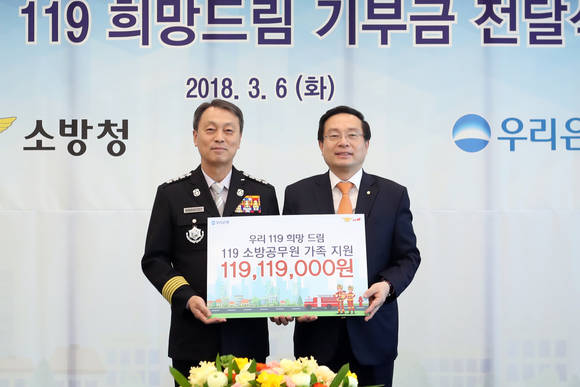 ▲우리은행은 지난 6일 서울 중구 본점에서 소방청에 '우리119희망드림 기부금 전달식'을 가졌다. 손태승 은행장(사진 오른쪽)이 기부금을 전달하고 조종묵 소방청장과 기념촬영을 하고 있다.(사진제공=우리은행)