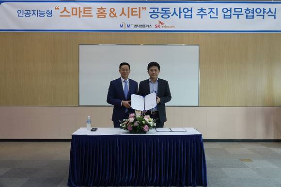 ▲구명완 엠디엠플러스 대표(왼쪽)와 허일규 SK텔레콤 IoT/데이터사업부장이 엠디엠플러스가 분양하는 주거상품에 SK텔레콤의 스마트홈 서비스를 단독 공급하는 업무협약을 맺은 뒤 기념촬영을 하고 있다. / 사진제공=SK텔레콤