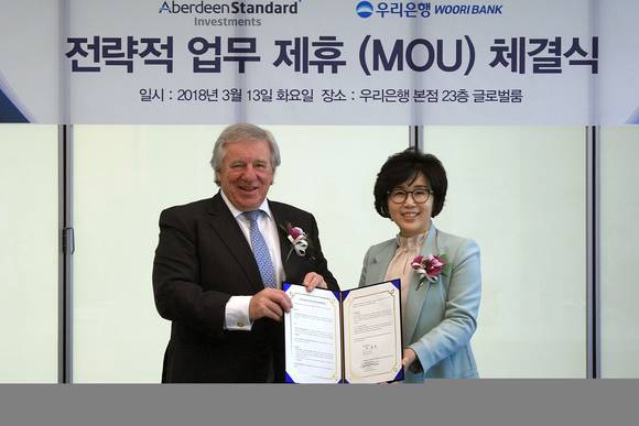 ▲우리은행은 지난 13일 서울 중구 본점에서 '우리은행-英 애버딘 스탠다드 인베스트먼츠와 전략적 업무제휴 협약'을 체결했다. 협약식에 참석한 정종숙 우리은행 WM그룹장(사진 오른쪽)이 마틴 길버트 애버딘 스탠다드 인베스트먼츠 CEO와 기념촬영을 하고 있다.(사진제공=우리은행)