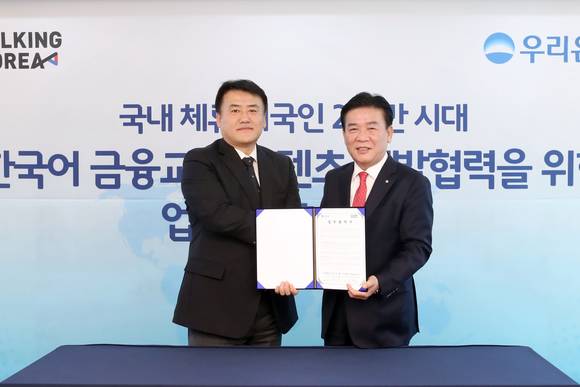 ▲우리은행은 지난 16일 서울 중구 본점에서 '우리은행-토킹코리아, 한국어 금융·교육 융합 서비스 개발을 위한 업무제휴 협약’을 체결했다. 김영배 우리은행 외환그룹 그룹장(사진 오른쪽)이 김형국 토킹코리아 대표와 기념촬영을 하고 있다.(사진제공=우리은행)