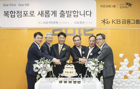 ▲KB국민은행-KB증권 복합점포 연수중앙지점 개점행사에 참석한 정기영 KB국민은행 인천지역영업그룹 대표(오른쪽 두번째), 이형일 KB증권 WM총괄본부장(왼쪽 두번째) 및 임직원들이 축하케이크를 자르고 있다.(사진제공=KB금융)
