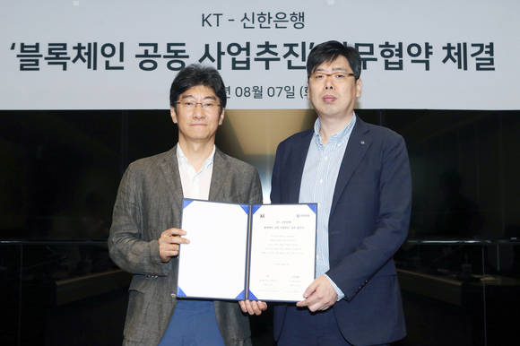 ▲지난 7일 서울 중구 세종대로 소재 KT사옥에서 진행된 업무협약식에서 장현기 신한은행 디지털전략본부 본부장(사진 우측)과 김학준 KT 상무(사진 좌측)가 기념촬영을 하는 모습.(사진제공=신한은행)