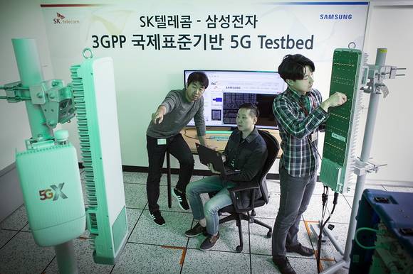 ▲SK텔레콤과 삼성전자 연구원들이 15일 SK텔레콤 분당사옥 5G 테스트베드에서 3.5GHz 대역 5G 상용장비로 퍼스트콜에 성공했다. / 사진=SK텔레콤