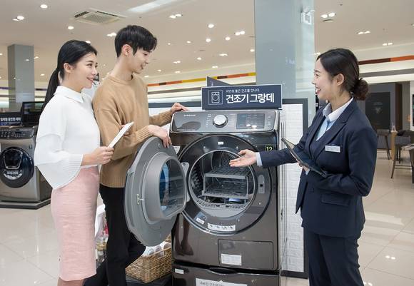 ▲삼성 건조기 ‘그랑데’ 16kg 신모델이 출시되자마자 큰 인기를 끌며 소비자 대상 체험단 모집에도 1만 명 이상의 지원자가 몰렸다. 디지털프라자 강남 본점에서 삼성전자 모델들이 그랑데를 구경하고 있다. / 사진=삼성전자
