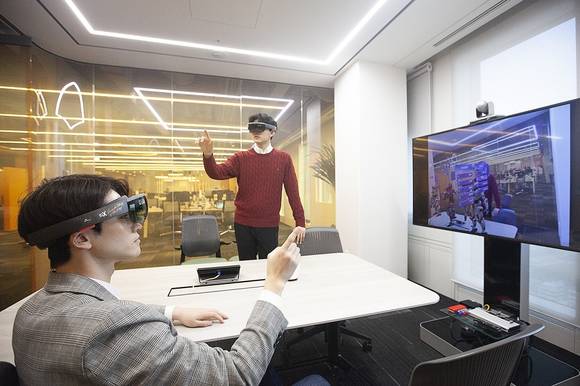 ▲SK텔레콤이 13일 서울 종로구 센트로폴리스빌딩에 5G와 인공지능 등 첨단 ICT 기술을 접목한 ‘5G 스마트오피스’를 공개했다. 사진은 SK텔레콤 직원들이 증강현실 글라스를 착용하고 T 리얼 텔레프리즌스로 가상공간에서 회의를 하고 있다. / 사진=SK텔레콤