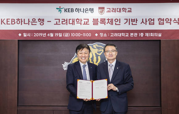 ▲KEB하나은행은 지난 19일 고려대학교와 블록체인기술 공동 연구를 위한 업무협약을 체결했다. 협약식 후 한준성 KEB하나은행 미래금융그룹 부행장(사진 왼쪽)과 이진한 고려대 연구부총장이 기념촬영을 하고 있다.(사진제공=KEB하나은행)