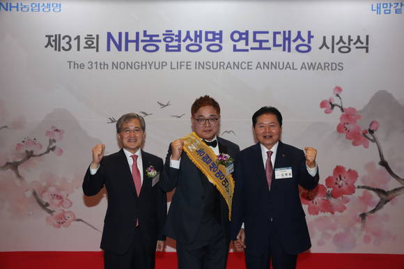 ▲NH농협생명이 25일 대전 유성구 소재 호텔ICC에서 개최한 '제31회 연도대상' 시상식에서 대상 수상자 윤순복 지점장(가운데)과 농협중앙회 김병원 회장(오른쪽), NH농협생명 홍재은 대표이사(왼쪽)가 기념 촬영을 하고 있다.(사진제공=NH농협생명)