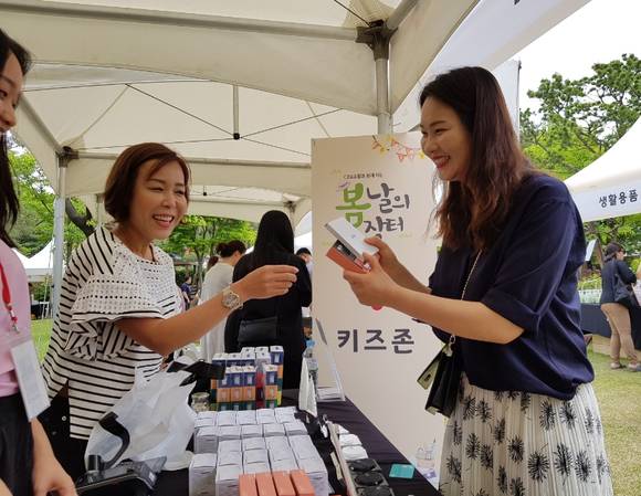 서울 서초구 방배동에 위치한 CJ오쇼핑 사옥 내 정원에서 열린 ‘봄날의 장터’ 행사 방문 고객이 뷰티용품을 구매하고 있다. 사진제공=CJ ENM 오쇼핑부문