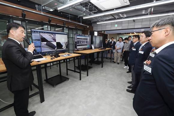 ▲지난 10일 경기도 성남시 분당구 스타트업캠퍼스에 문을 연 KT 판교 5G 오픈랩에서 참석자들이 링크플로우의 넥밴드에 대한 설명을 듣고 있다. / 사진=KT