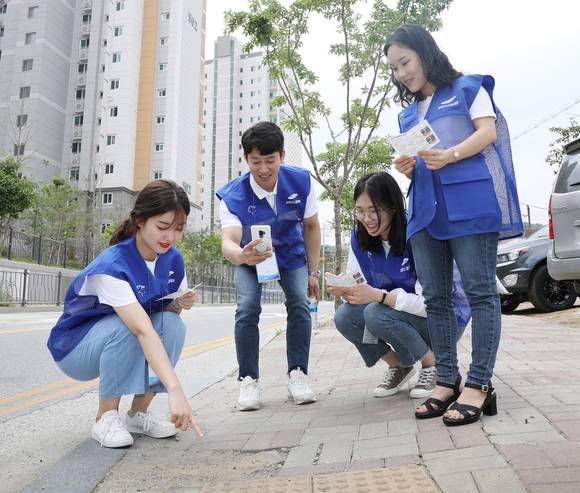 ▲삼성디스플레이 신입사원들이 파손된 보행시설을 발견하고, 스마트폰 맵시스템을 활용해 위치를 입력하고 있다. / 사진=삼성디스플레이