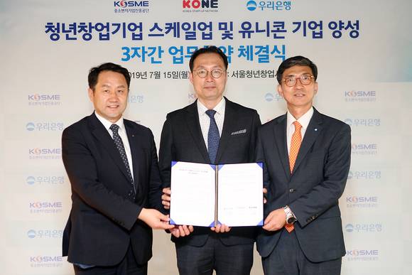 ▲우리은행은 지난 15일 서울 청년창업사관학교에서 중소벤처기업진흥공단 및 KONE와 '청년창업기업의 스케일업 및 유니콘 기업 양성'을 위한 업무 협약을 체결했다. 신명혁 우리은행 중소기업그룹 부행장(오른쪽)이 김은광 중소벤처기업진흥공단 청년창업사관학교 교장(왼쪽), 장욱진 KONE 회장(가운데)과 기념촬영을 하고 있다. (사진제공=우리은행)