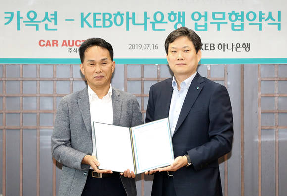 ▲KEB하나은행은 서울 을지로 본점에서 카옥션과 '자동차 플랫폼 비즈니스' 활성화를 위한 전략적 업무 협약을 체결했다고 17일 밝혔다. 업무협약식 후 이장성 KEB하나은행 영업지원본부장(오른쪽)과 장영수 카옥션 대표(왼쪽)가 기념촬영을 하고 있다.(사진제공=KEB하나은행)