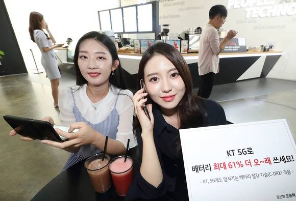 ▲KT는 5G C-DRX 기술을 서울·수도권, 강원, 부산, 울산, 경남 등에 적용했고 7월 말까지 전국 확대를 끝내겠다고 21일 밝혔다. KT 직원들이 5G C-DRX 기술을 적용해 배터리 사용 시간이 최대 61% 늘어난 스마트폰을 이용하고 있다. / 사진=KT