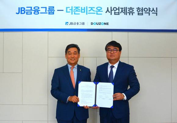 ▲김용우 더존비즈온 대표(오른쪽)와 김기홍 JB금융그룹 회장이 ‘중소·중견기업 맞춤형 디지털 금융서비스 제공’에 관한 사업제휴 양해각서를 체결한 뒤 업무협약서를 교환하고 있다. / 사진=더존비즈온