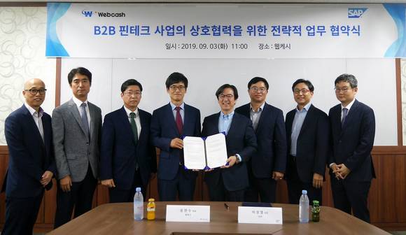 ▲윤완수 웹케시 대표(왼쪽 네 번째)와 이성열 SAP코리아 대표(다섯 번째)가 3일 B2B 핀테크 사업의 상호협력을 위한 전략적 업무협약을 체결한 뒤 두 회사 관계자들과 기념촬영을 하고 있다. / 사진=웹케시
