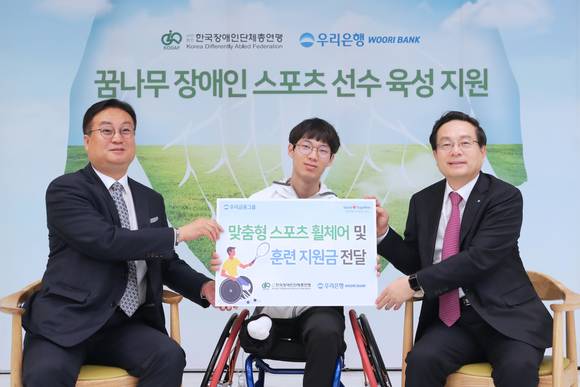 ▲우리금융그룹은 오는 11일 지체장애인의 날을 맞아 전국장애인단체총연맹에 후원금을 전달했다고 6일 밝혔다. 자리에 참석한 손태승 우리금융그룹 회장 겸 우리은행장(오른쪽부터)이 유수영 선수, 홍순봉 전국장애인단체총연맹 상임대표와 기념촬영을 하고 있다.(사진제공=우리금융그룹)