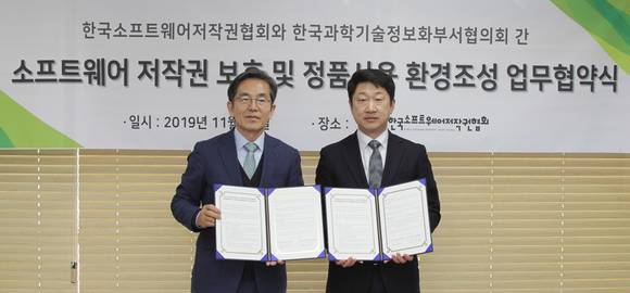 ▲유병한 한국SW저작권협회 회장(왼쪽)과 최연호 국가과학기술정보화부서협의회 회장이 18일 정부출연연구기관들의 효과적인 SW 관리체계 구축 및 정품SW 사용환경 조성을 위해 업무협약을 체결한 뒤 기념촬영을 하고 있다. / 사진=한국SW저작권협회