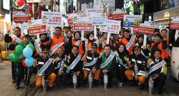 ▲하이트진로가 12일 부산시 부전 시장 및 서면 일대에서 상가의 화재 취약계층을 위한 소방안전캠페인을 진행했다. 이 날 행사에 참석한 김인규 하이트진로 대표이사(첫째줄 오른쪽에서 네번째)와 변수남 부산소방본부장(첫째줄 오른쪽에서 다섯번째) 등이 기념촬영을 하고 있다.(사진제공=하이트진로)