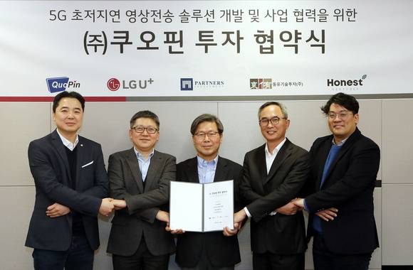 ▲조원석 LG유플러스 전무(왼쪽 두 번째), 이상훈 쿠오핀 대표(세 번째) 등 관계자들이 5G 원격제어 핵심기술인 초저지연 영상전송 솔루션 상용화를 위한 지분투자협약을 체결한 뒤 기념촬영을 하고 있다. / 사진=LG유플러스