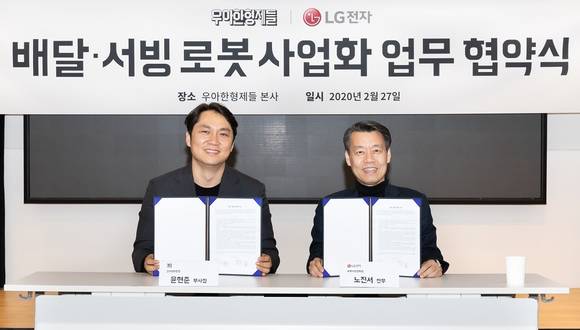 ▲노진서 LG전자 로봇사업센터장(오른쪽)과 윤현준 우아한형제들 신사업부문장이 27일 서울 송파구 우아한형제들 본사에서 배달·서빙로봇 관련 사업협력을 위해 업무협약을 맺은 뒤 기념촬영을 하고 있다. / 사진=LG전자