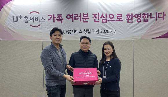 ▲LG유플러스는 자사 홈·미디어 고객서비스(CS)를 전담하는 자회사 U+홈서비스가 공식 출범했다고 3일 밝혔다. 정용일 U+홈서비스 대표(가운데)가 직원들에게 사원증, 명함 등이 포함된 ‘웹컴팩(Welcome Pack)’을 전달하고 있다. / 사진=LG유플러스