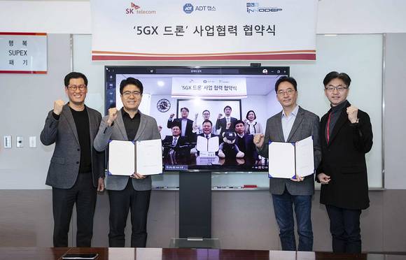 ▲SK텔레콤, ADT캡스, 이노뎁이 지난 18일 영상통화로 5G 산업용 드론 사업화를 위한 협약식을 진행했다. 박진효 SK텔레콤 보안사업부장(ADT캡스 대표 겸임, 왼쪽 두 번째), 김윤 SK텔레콤 CTO(세 번째), 이노뎁 이성진 대표(영상 속 앞줄 왼쪽 두 번째) 등 관계자들이 협력을 다짐하고 있다. / 사진=SK텔레콤