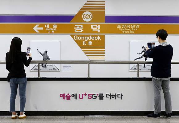 ▲서울 지하철 6호선 공덕역에 마련된 5G 기반 문화예술공간 ‘U+5G 갤러리’에 방문한 고객이 ‘U+AR’ 앱으로 작품을 체험하고 감상하고 있다. / 사진=LG유플러스