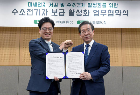 ▲공영운 현대차 사장(왼쪽)과 박원순 서울시장(오른쪽)이 지난 달 31일 서울시 신청사에서 열린 수소전기차 보급 활성화 업무협약식에서 양해각서를 들고 기념촬영을 하고 있다. (사진제공=현대자동차)