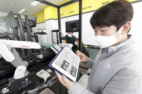 ▲KT와 코그넥스 직원들이 경기도 수원 코그넥스코리아 연구소에서 ‘KT 5G 스마트팩토리 머신비전’ 솔루션을 점검하고 있다. / 사진=KT