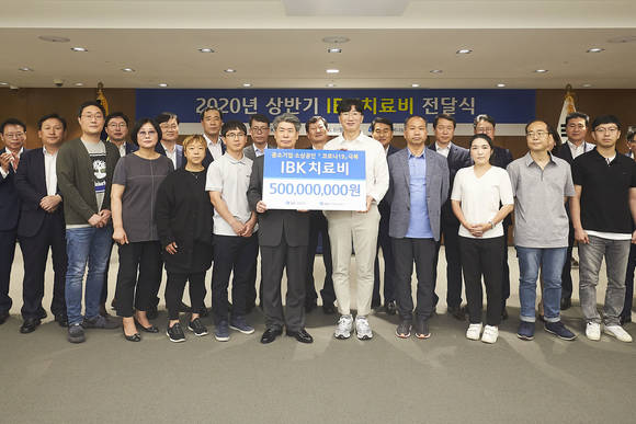 ▲8일 서울 을지로 기업은행 본점에서 윤종원 IBK기업은행장(왼쪽 열한 번째)과 중소기업 근로자 가족들이 치료비 전달식을 마치고 기념촬영을 하고 있는 모습.(사진제공=IBK기업은행)
