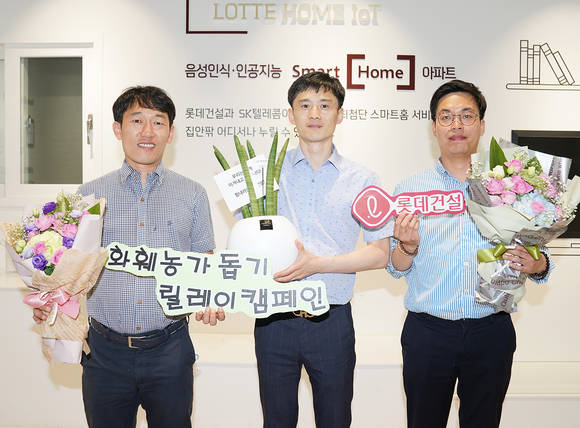 ▲롯데건설 대구 C/S센터 근무자들이 꽃다발과 공기정화 식물이 담긴 화분을 들고 사진을 찍고 있다.(사진제공=롯데건설)