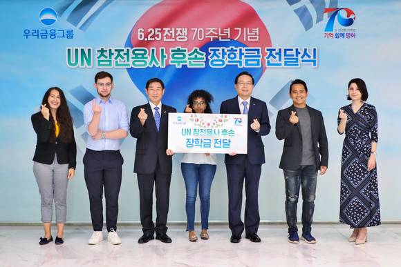 ▲우리금융그룹은 6월 호국보훈의 달 및 6·25전쟁 70주년을 맞아 지난 22일 서울 중구 회현동 우리금융그룹 본사에서 UN 참전용사 후손들에게 장학금 1억 원을 전달했다. 손태승 우리금융그룹 회장(왼쪽 다섯번째)이 김은기 6·25전쟁 70주년 사업추진위원회 공동위원장(왼쪽 세번째) 및 UN참전용사 후손들과 기념촬영을 하고 있다.(사진출처=우리은행)