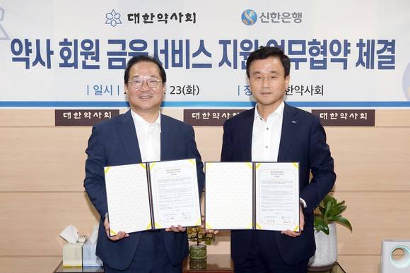 ▲23일 서울시 서초구 소재 대한약사회 본사에서 진행된 업무 협약식에서 박우혁 신한은행 부행장(오른쪽)과 김대업 대한약사회 회장이 기념촬영 하는 모습.(사진제공=신한은행)
