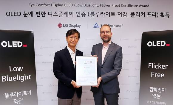 ▲오창호 LG디스플레이 TV사업부장(왼쪽)과 카스텐 리네만 티유브이 라인란드 한국 대표가 지난달 30일 서울 여의도 LG트윈타워에서 열린 LG디스플레이 OLED TV 패널 플리커 프리 인증식에서 기념촬영을 하고 있다. / 사진=LG디스플레이