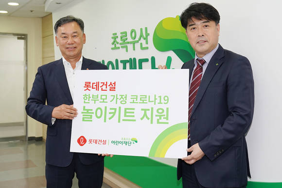 ▲오기종 롯데건설 전무(왼쪽)와 이형진 초록우산어린이재단 본부장이 서울지역 어린이들을 위한 '놀이 키트' 전달식을 진행했다. / 사진=롯데건설