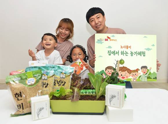 ▲SK하이닉스 장윤숙 기장(이천FAB제조팀) 가족이 노사불이 ‘집에서 하는 농가 체험 박스’를 전달받고 환하게 웃고 있다. / 사진=SK하이닉스