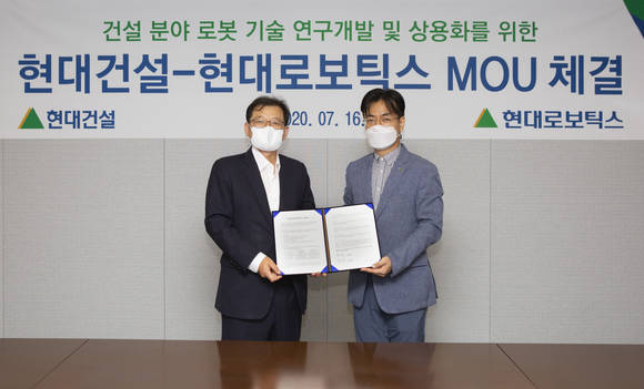 ▲박구용 현대건설 기술연구소장(왼쪽)과 윤대규 현대로보틱스 로봇연구소장이 '건설 로보틱스 분야 연구협력' MOU를 체결하고 기념촬영하는 모습 / 사진=현대건설