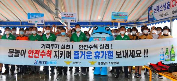 ▲지난달 31일 충남 보령시 대천수욕장 119해변구조대에서 진행된 물품 전달식에서 김인규 하이트진로 대표(앞줄 왼쪽 여섯 번째) 등 참석자들이 기념촬영을 하고 있다. / 사진=하이트진로