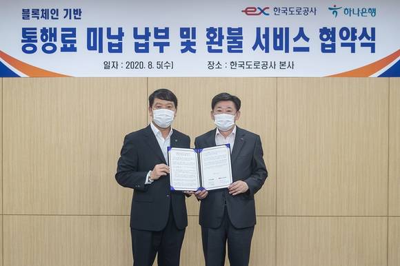 ▲염정호 하나은행 미래금융그룹장(왼쪽)과 이광호 한국도로공사 영업본부장이 지난 5일 경북 김천 한국도로공사 본사에서 블록체인 기술 기반 서비스 도입 업무협약을 체결한 뒤 기념촬영을 하고 있다. / 사진=하나은행