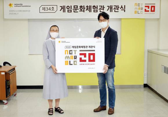 ▲김희정 성프란치스꼬장애인종합복지관 관장(왼쪽)과 이승원 넷마블문화재단 대표가 게임문화체험관 개관식에서 사진을 찍고 있다. / 사진=넷마블문화재단