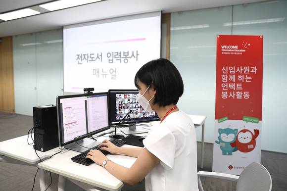 ▲롯데정보통신 신입사원이 언택트 환경에서 전자도서 입력 매뉴얼에 맞춰 점자책 만들기 활동을 진행하고 있다. / 사진=롯데정보통신