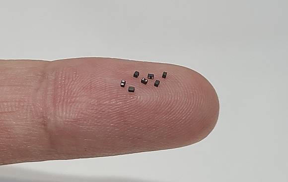 ▲삼성전기가 개발한 세계 최소형(가로 0.8mm, 세로 0.4mm) 파워인덕터를 손가락 위에 올려놓았다. / 사진=삼성전기